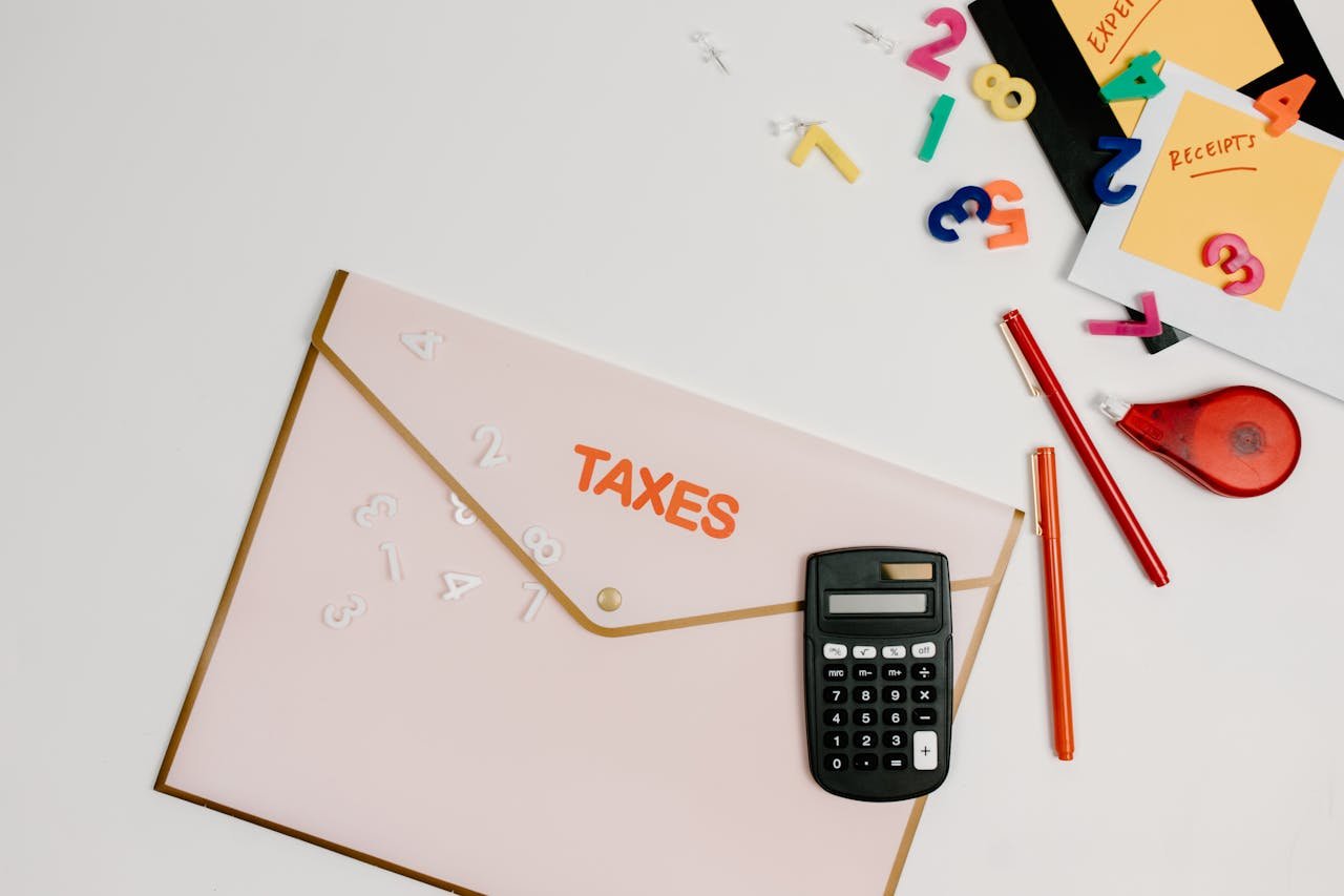 Home Flat lay of a tax preparation workspace with calculator, envelope, and colorful numbers.