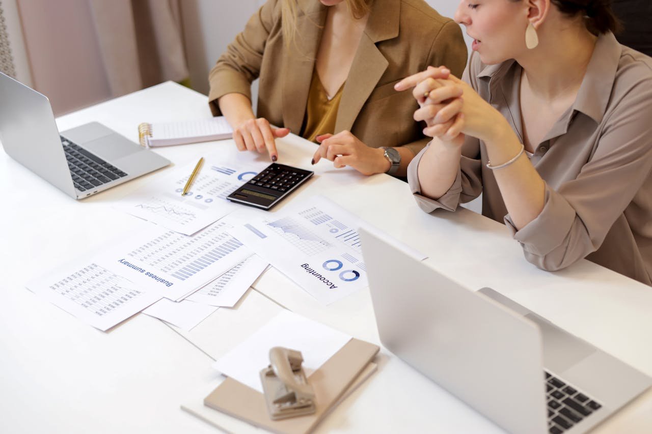 Home Two professionals collaborating on financial documents in a modern office setting.